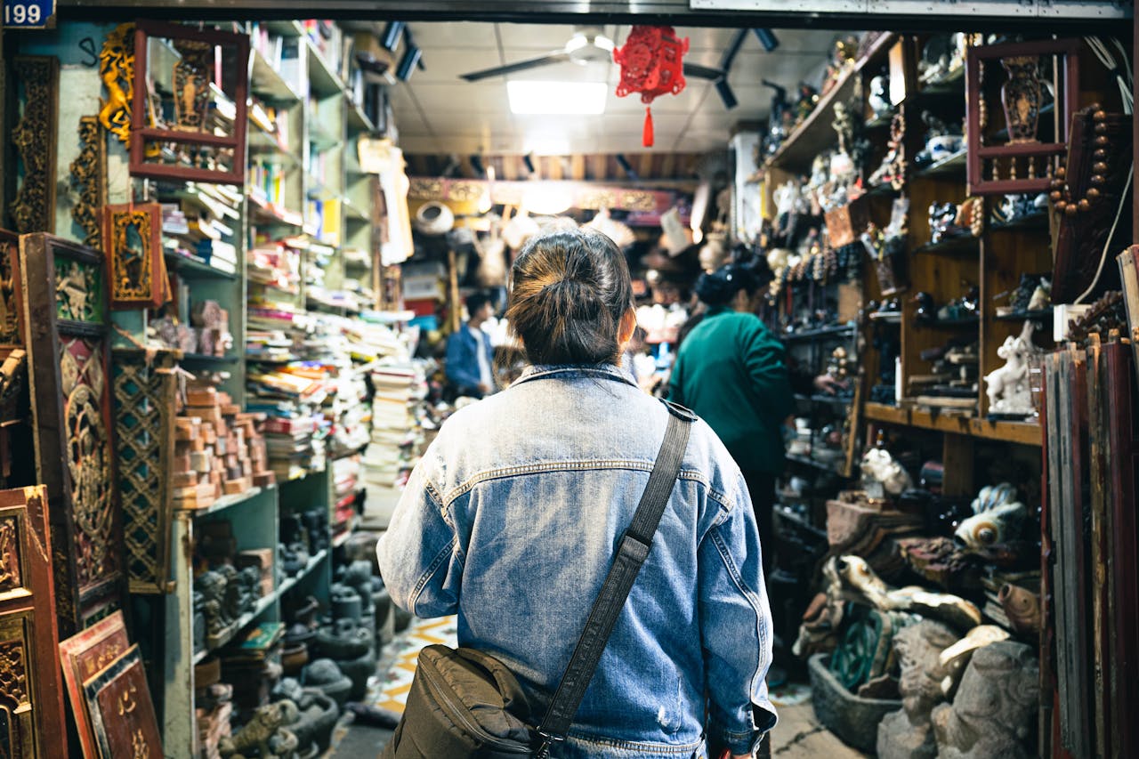 A person browsing through a bustling antique store filled with vintage treasures and cultural artifacts.